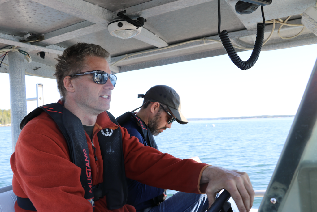 Two people drive a boat. 